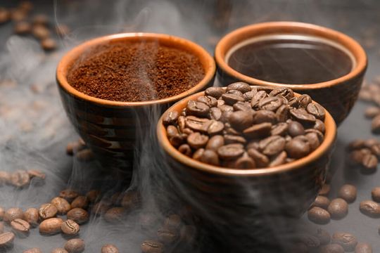 tres cuencos con café en grano, molido y líquido
